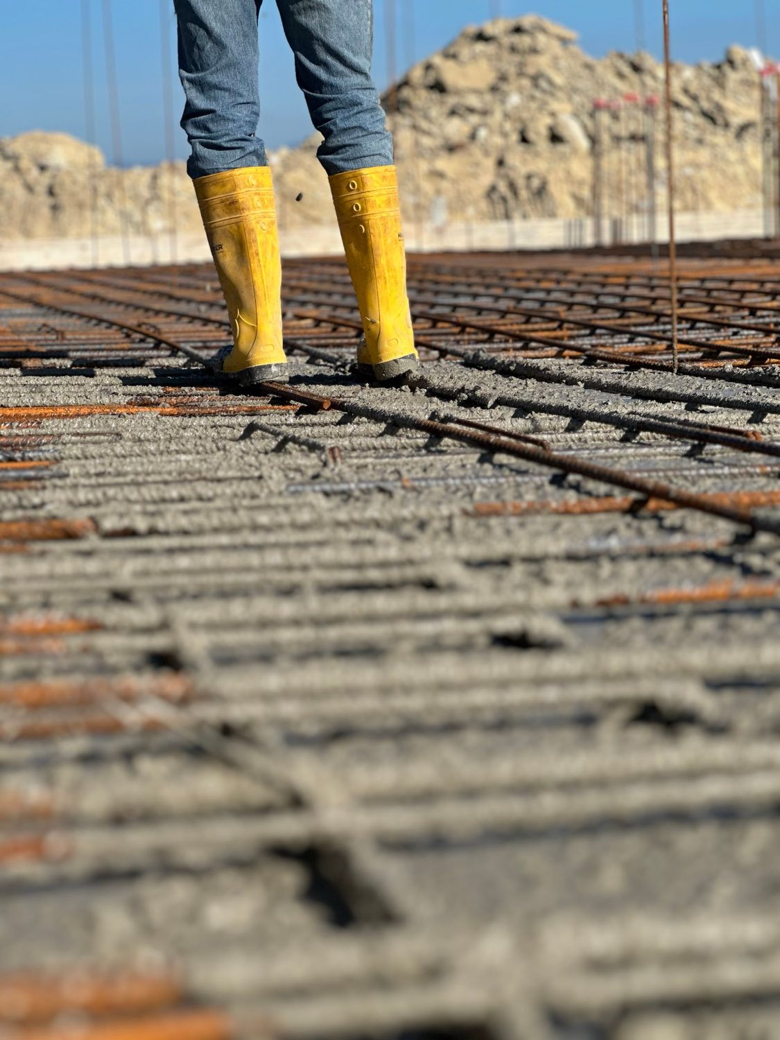 Worker standing on a rebar mat during a concrete pour